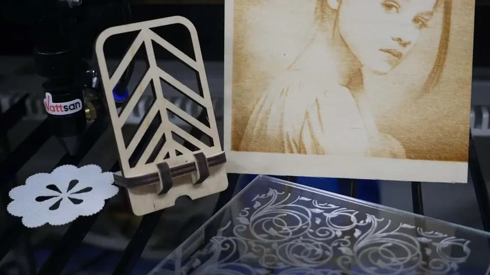 Ассорти лазерных изделий: ажурная подставка под телефон из фанеры, портрет, выжженный на дереве, и акриловая пластина с узором